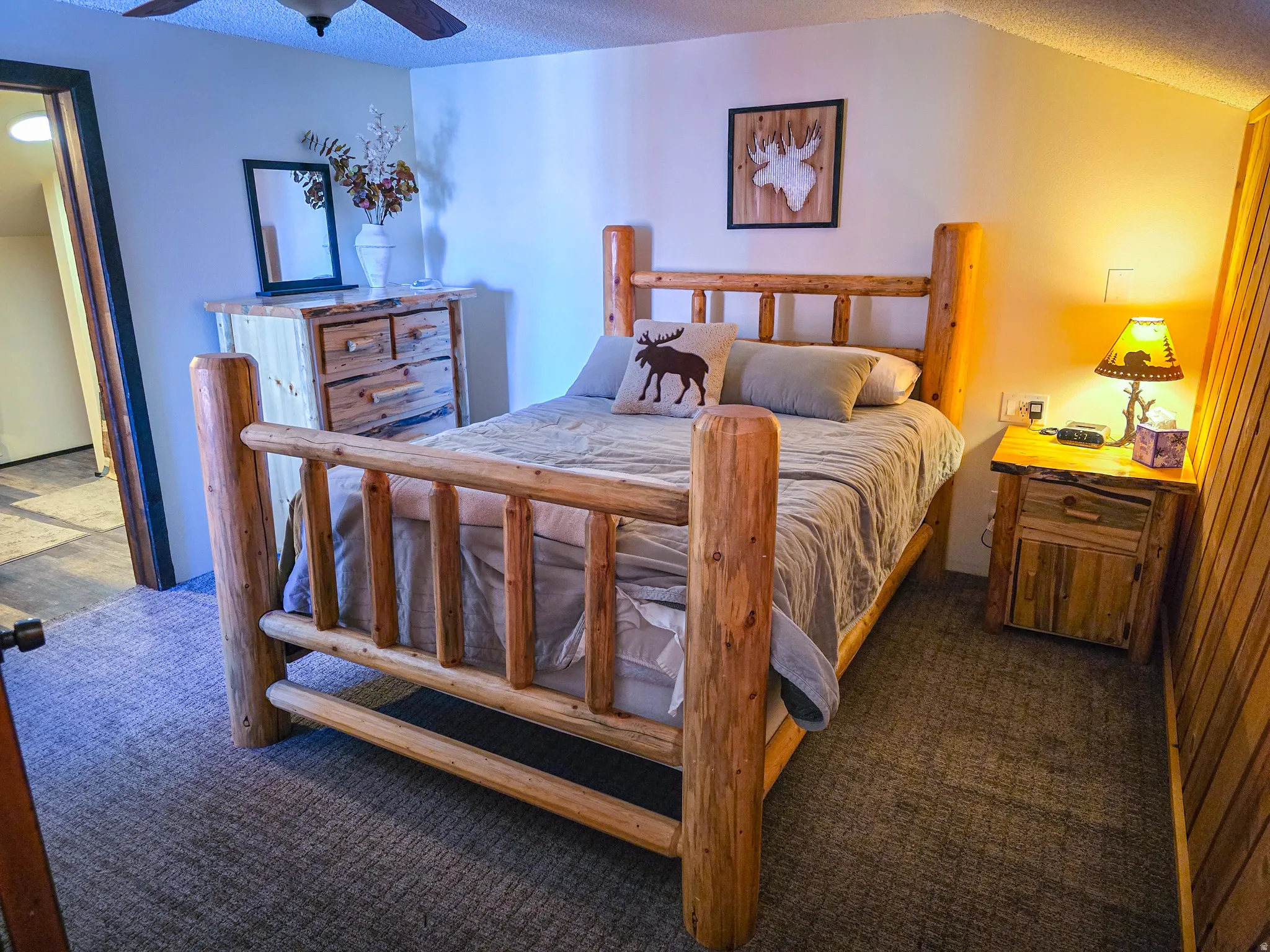 Bedroom featuring a textured ceiling, dark carpet, and ceiling fan