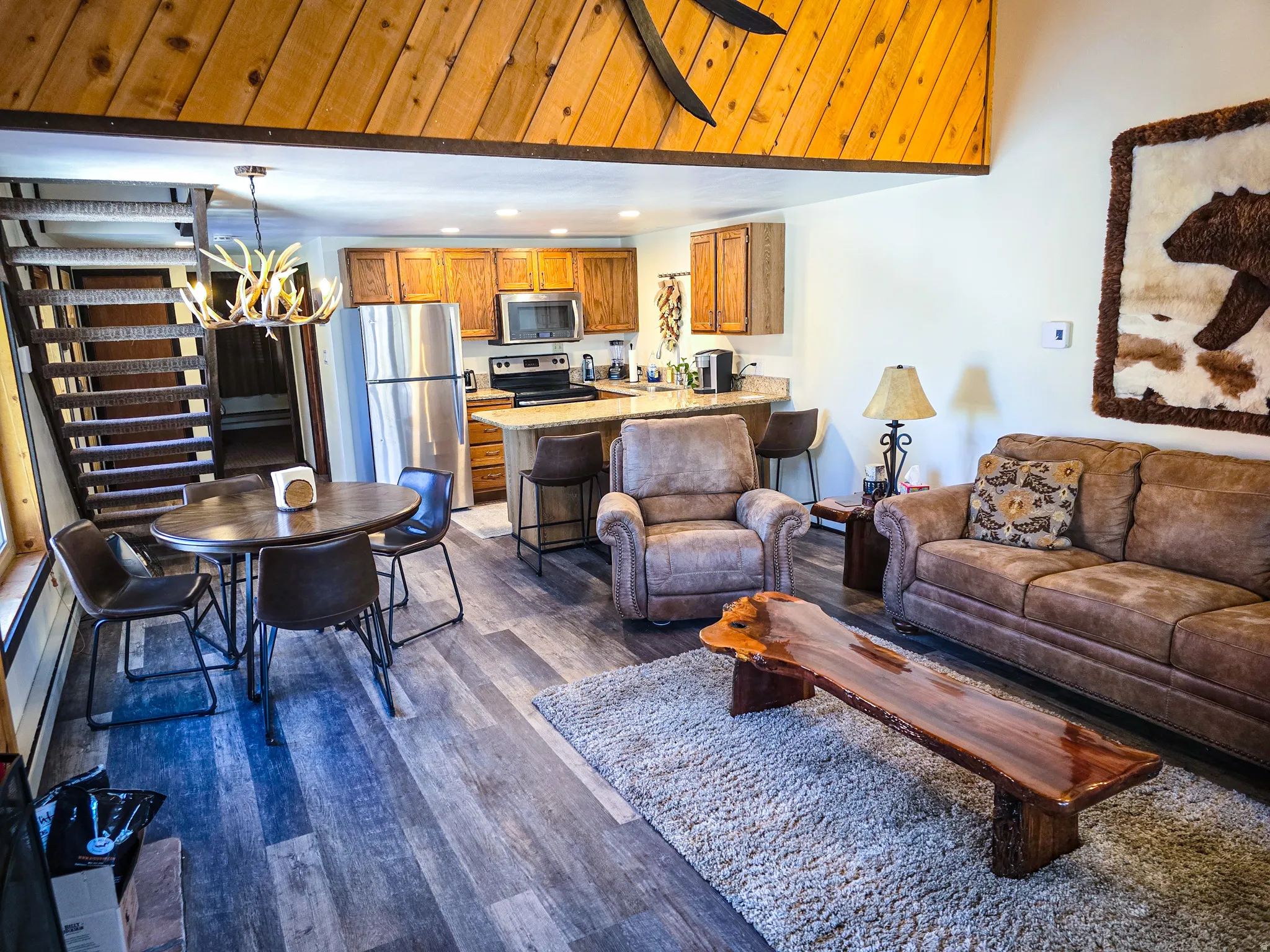Living room with dark wood-style flooring, a chandelier, and recessed lighting