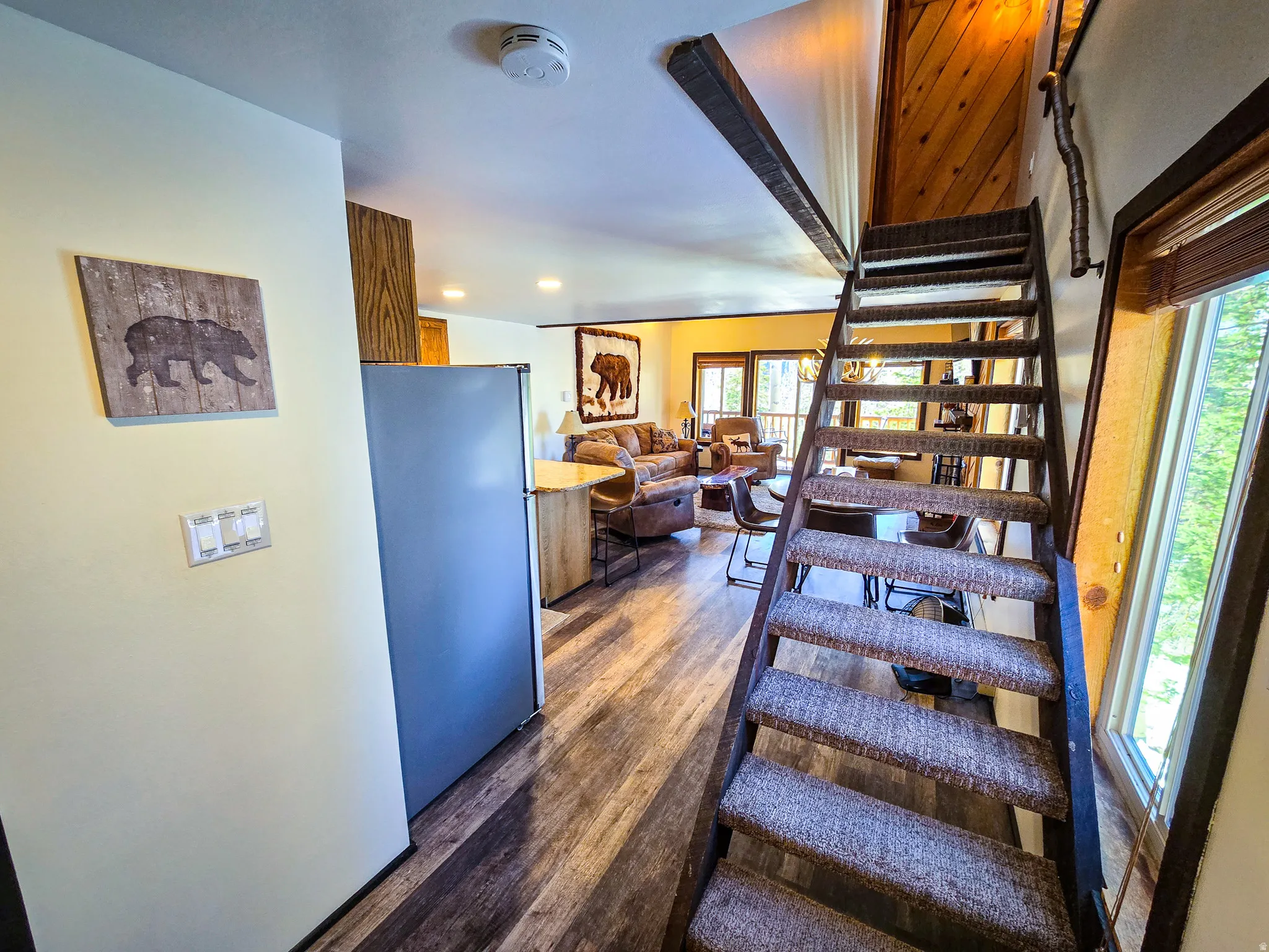 Staircase with wood finished floors and recessed lighting