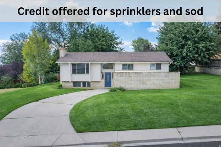 Split foyer home with brick siding, a front yard, and a chimney