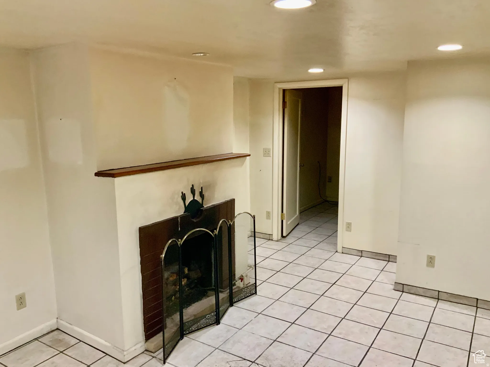 Living area featuring light tile patterned flooring, a fireplace, and recessed lighting