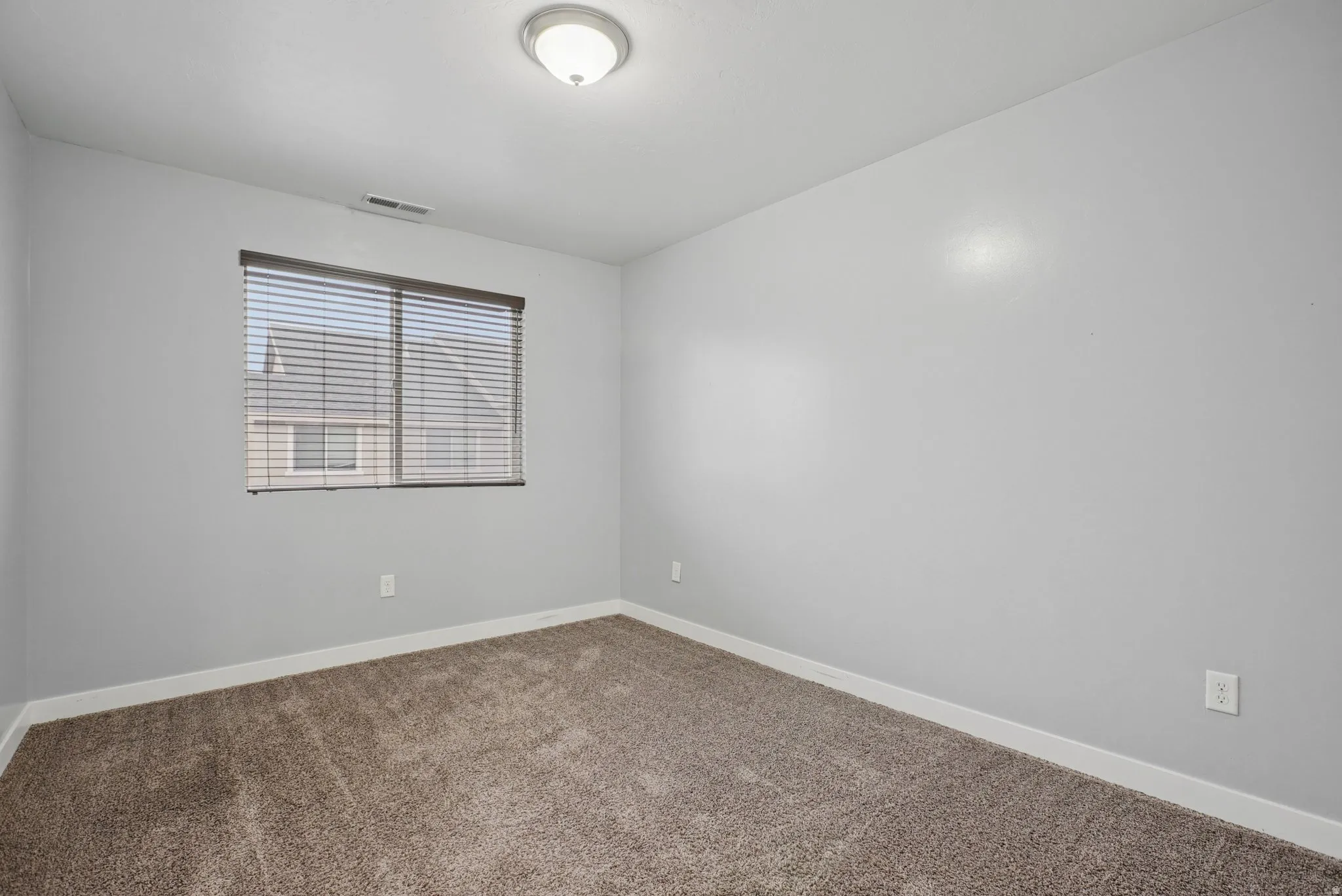 Carpeted spare room with baseboards