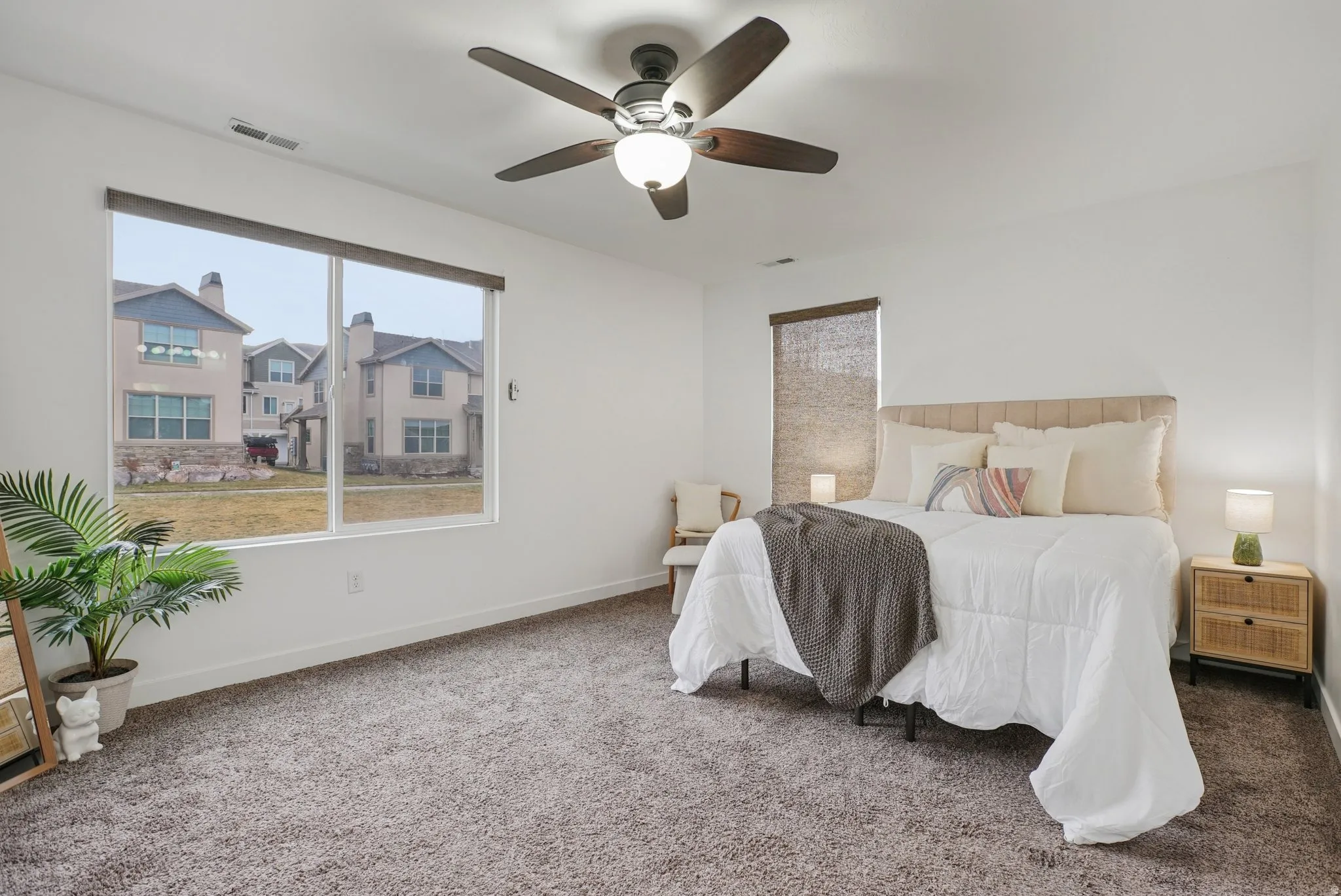 Carpeted bedroom with baseboards and a ceiling fan