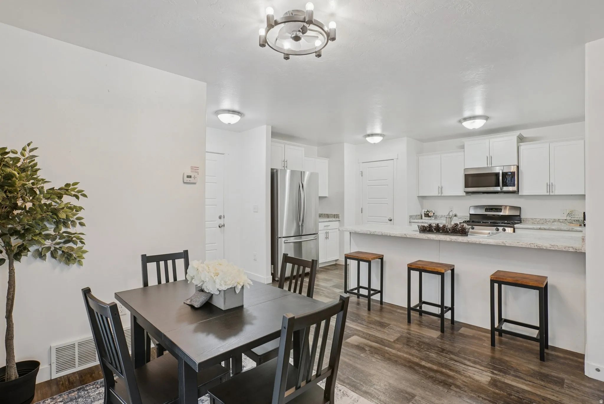 Dining room with dark wood-type flooring and a chandelier