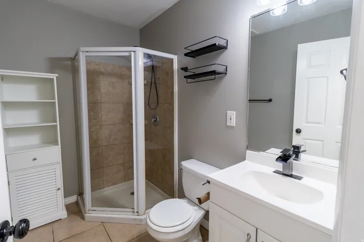Full bathroom featuring light tile patterned flooring, vanity, and a stall shower