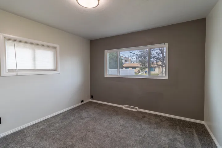 Empty room featuring baseboards and carpet flooring