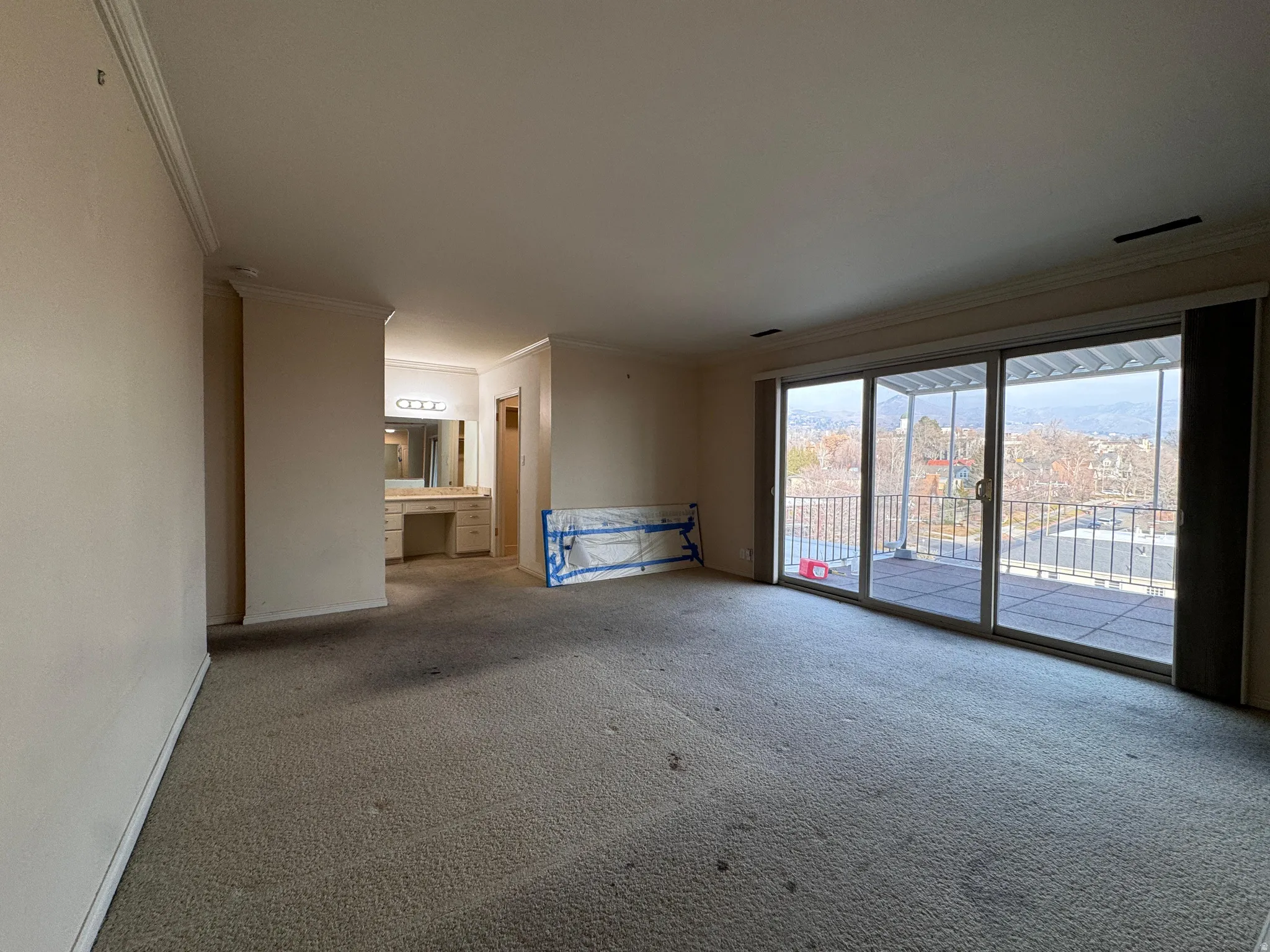Unfurnished living room with ornamental molding and carpet floors