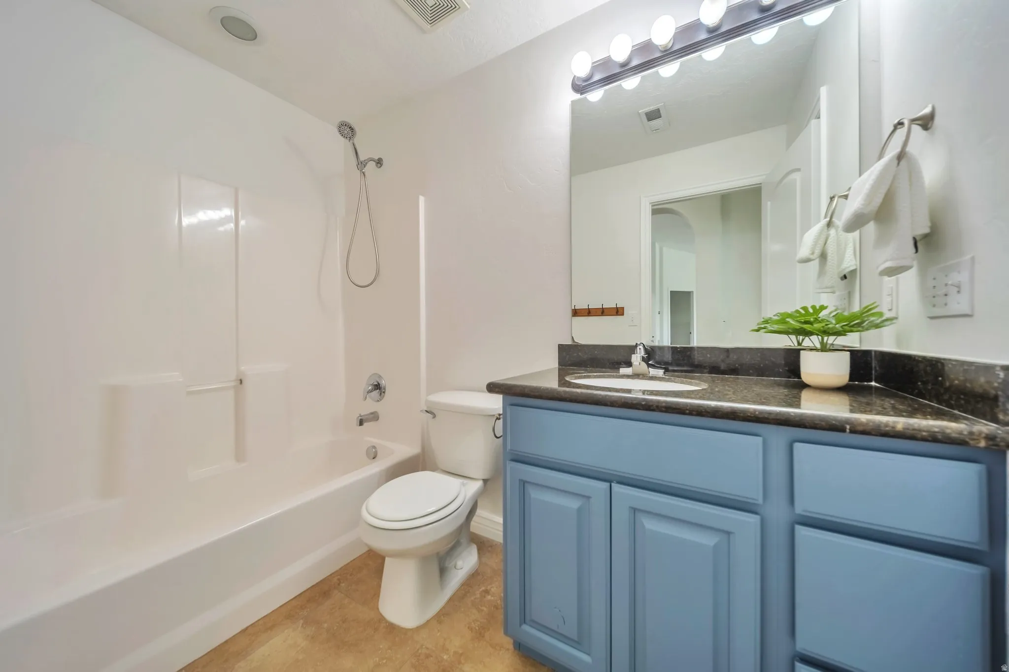 Full bath featuring shower / bathtub combination, vanity, and light tile patterned flooring