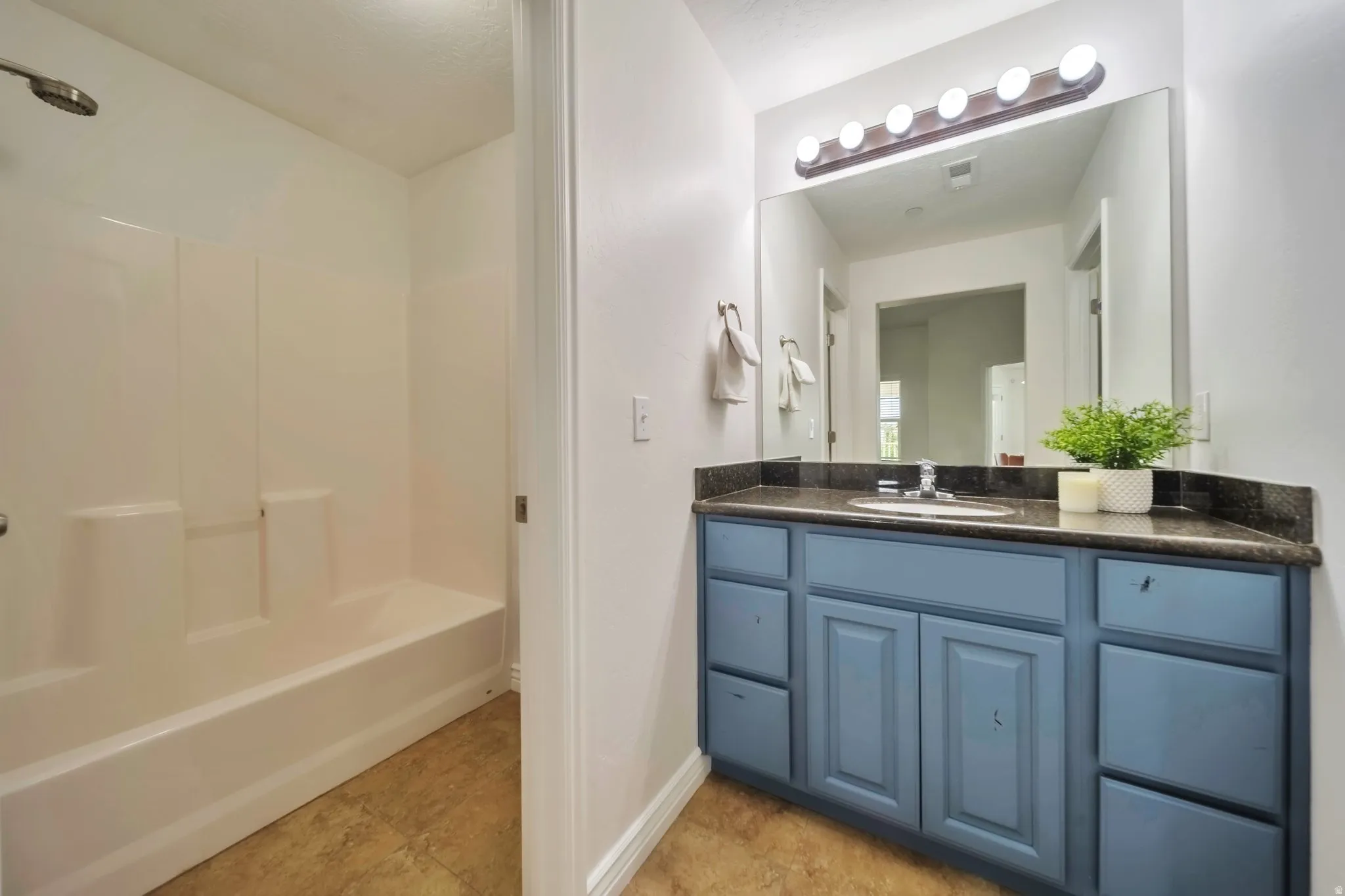 Bathroom featuring vanity and bathing tub / shower combination
