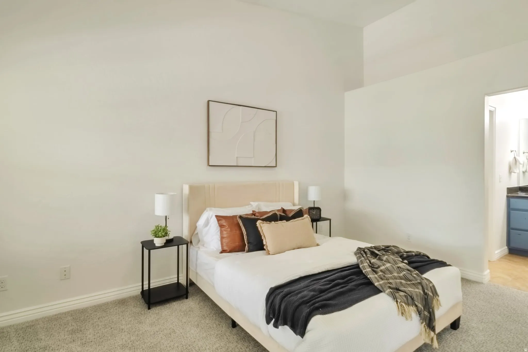 Bedroom with light carpet and ensuite bath