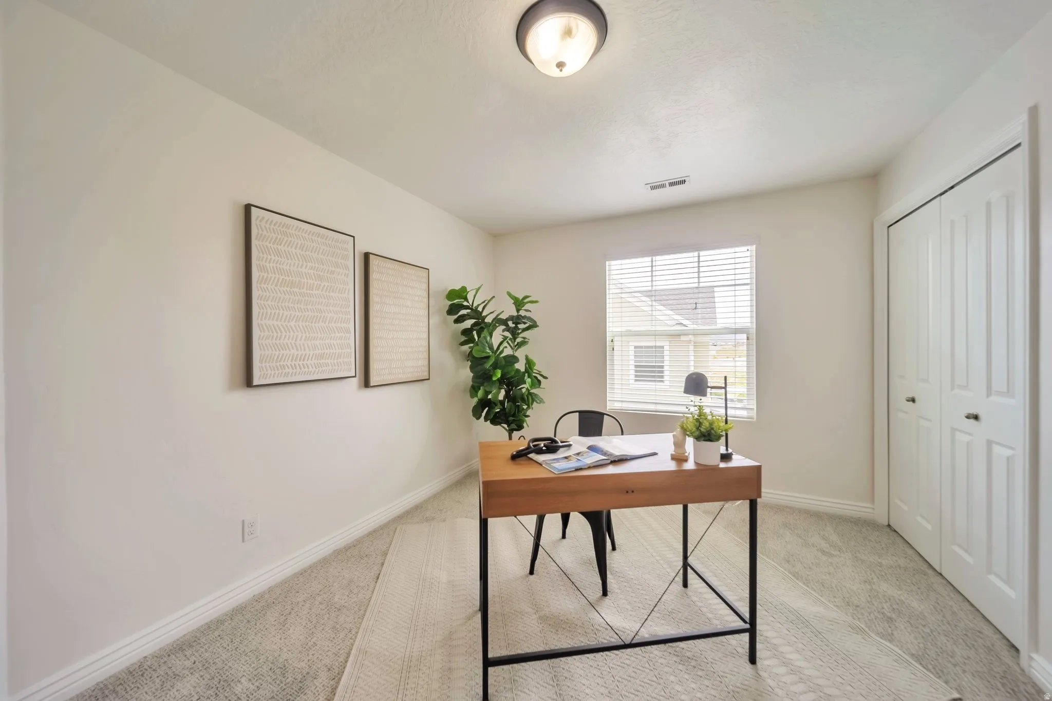 Home office featuring light carpet and baseboards
