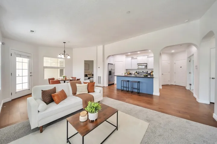 Living area featuring arched walkways, a chandelier, and dark wood-type flooring