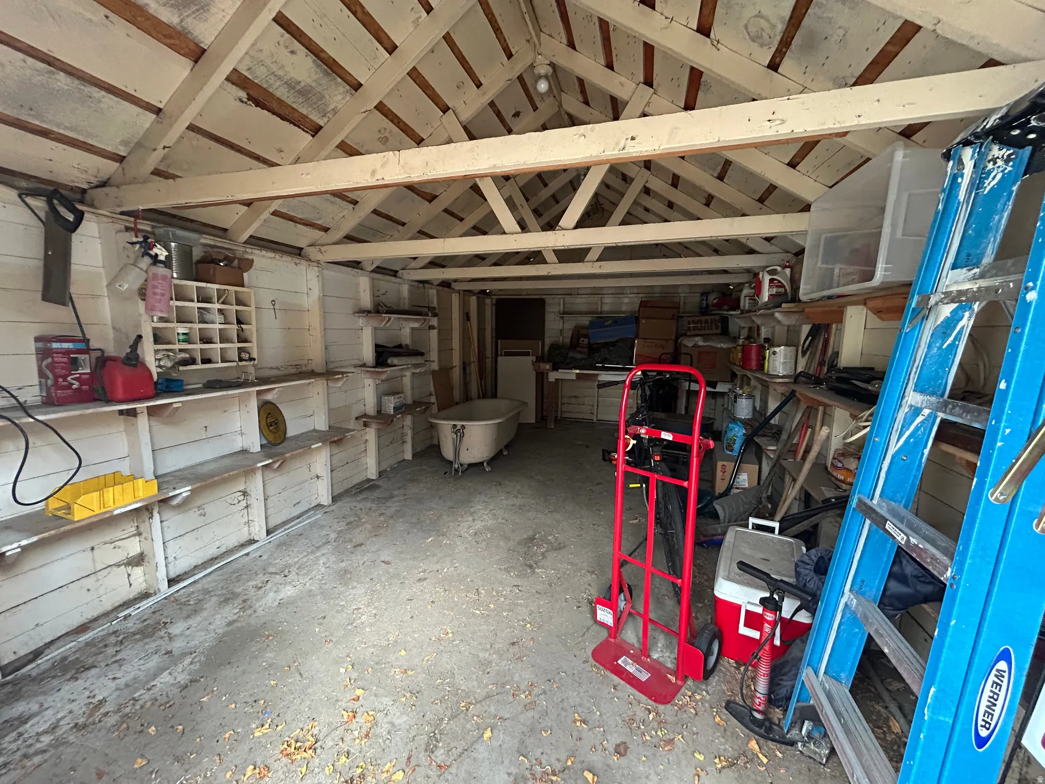 Miscellaneous room with lofted ceiling and unfinished concrete flooring