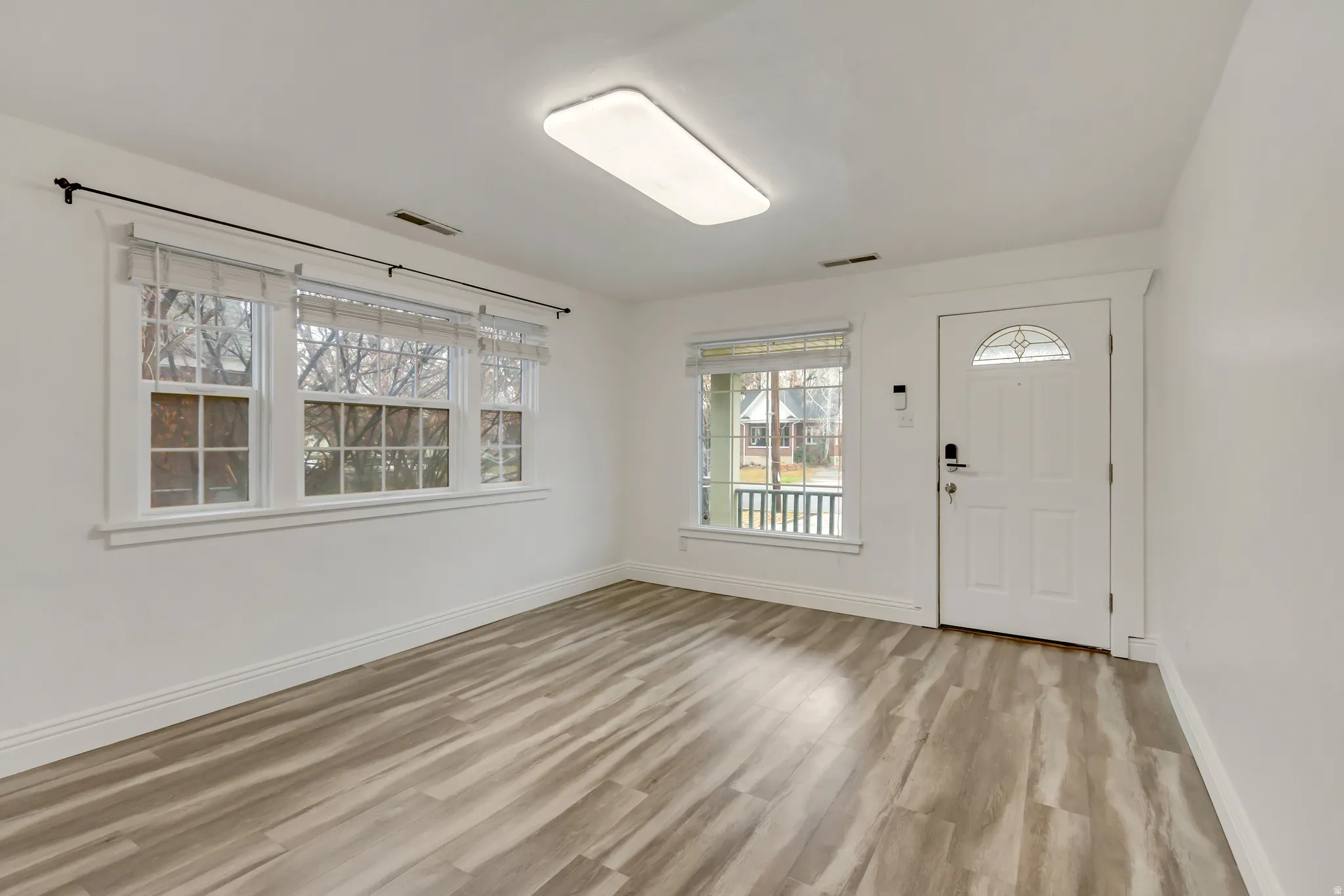 Foyer with baseboards and light wood-style floors