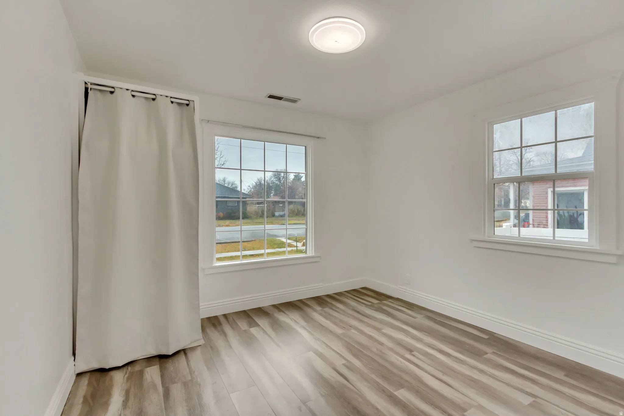 Spare room with baseboards and light wood-style floors