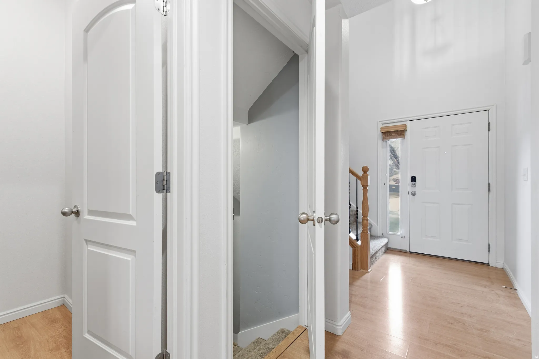 Entryway featuring stairs, light wood-style floors, and a high ceiling