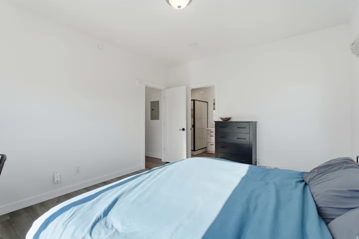 Bedroom featuring wood finished floors and electric panel