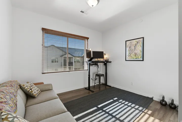 Workout area featuring dark wood-style flooring and baseboards