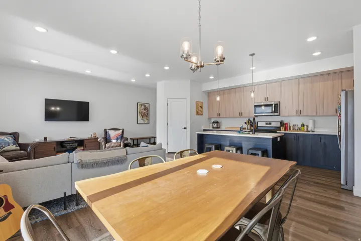 Dining room with dark wood-style flooring, recessed lighting, and a chandelier