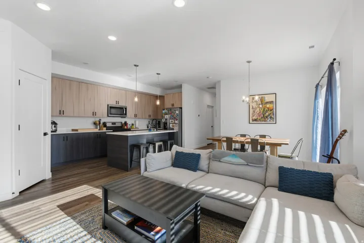 Living area featuring dark wood-style flooring, a chandelier, and recessed lighting
