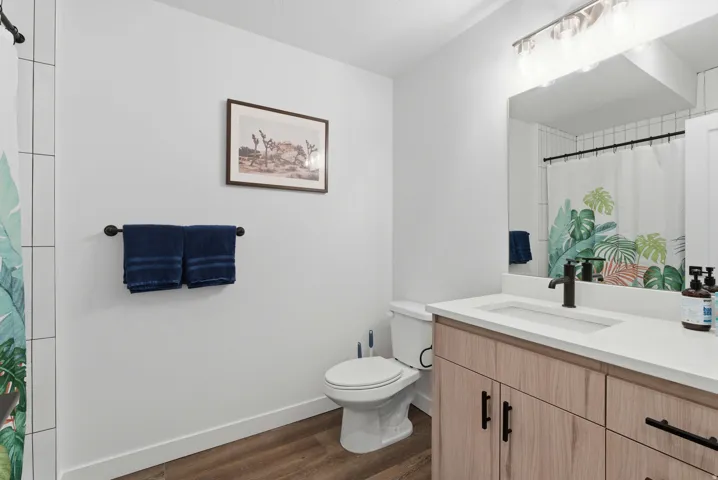 Bathroom with a shower with curtain, vanity, and dark wood finished floors