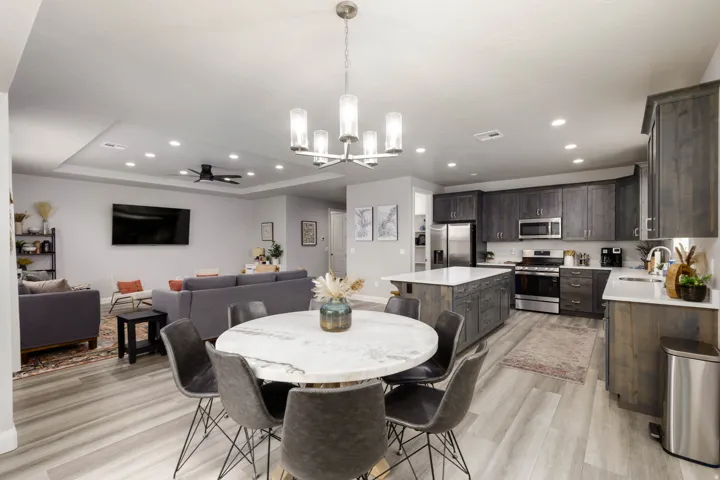 Dining room with recessed lighting, ceiling fan, a chandelier, light wood-type flooring, and a raised ceiling