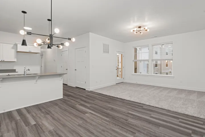Kitchen featuring a chandelier, white cabinetry, pendant lighting, and a kitchen breakfast bar