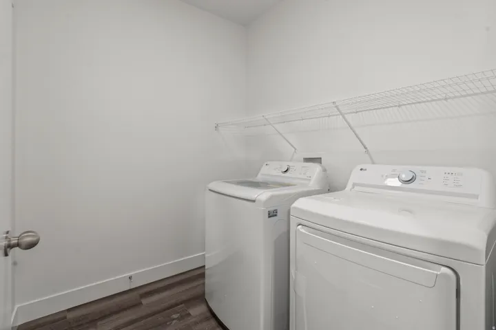 Washroom with dark wood-style flooring and independent washer and dryer