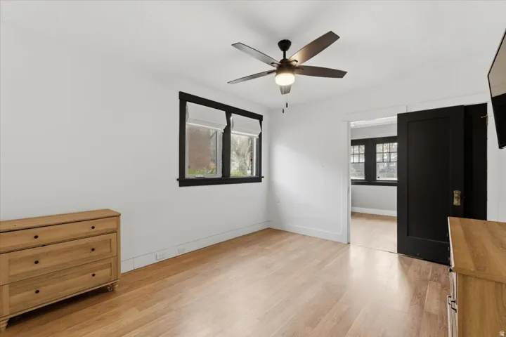 Unfurnished bedroom with ceiling fan and light wood finished floors