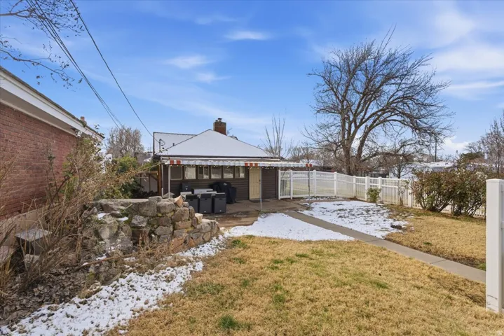 Yard covered in snow with a fenced backyard and a patio area