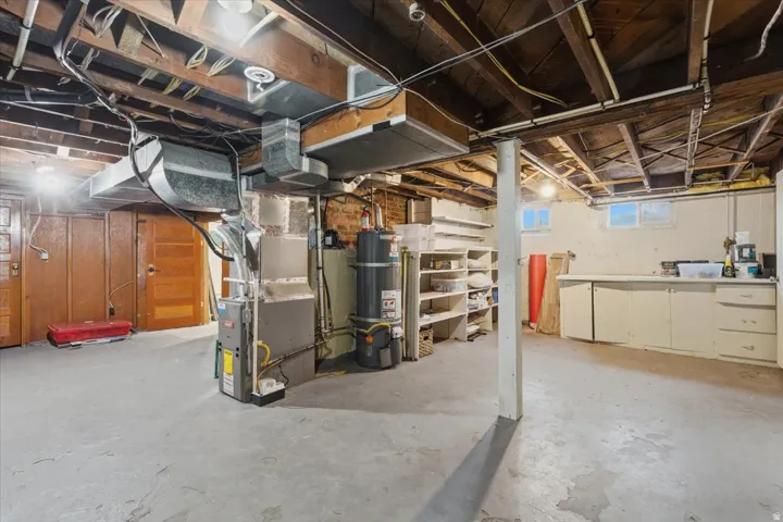 Below grade area featuring strapped water heater and heating unit