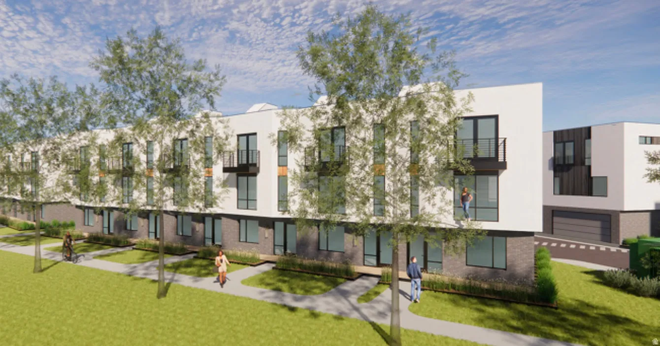 Modern townhome-style residences featuring white facade, dark brick lower levels, large windows, and private balconies with black railings