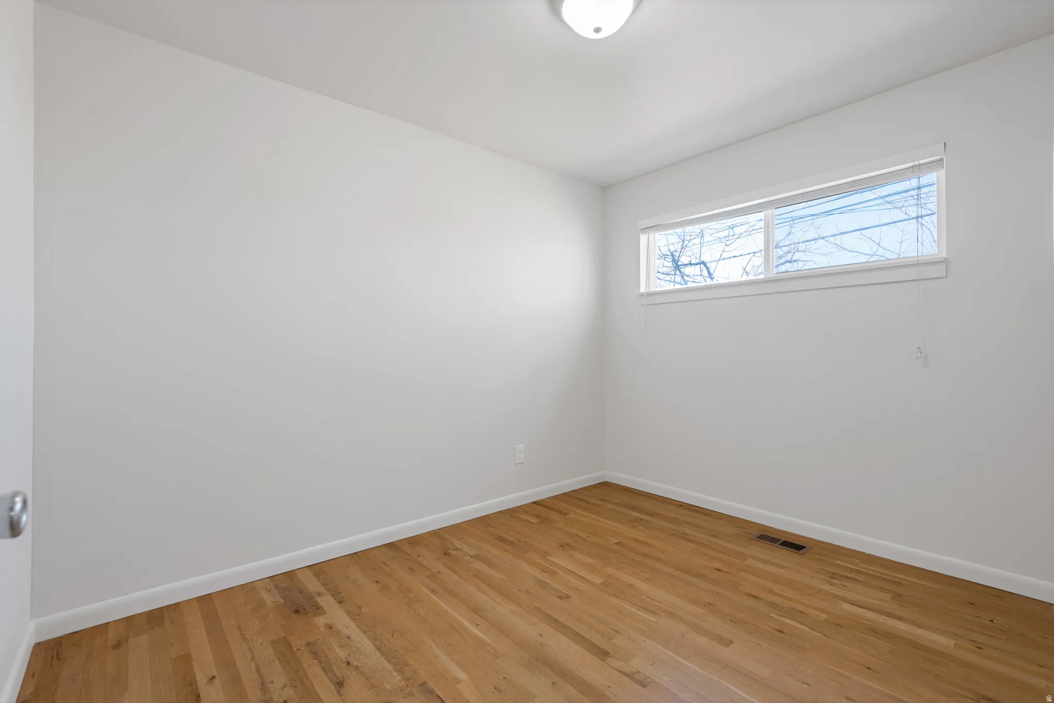 Unfurnished room with baseboards and light wood-style floors