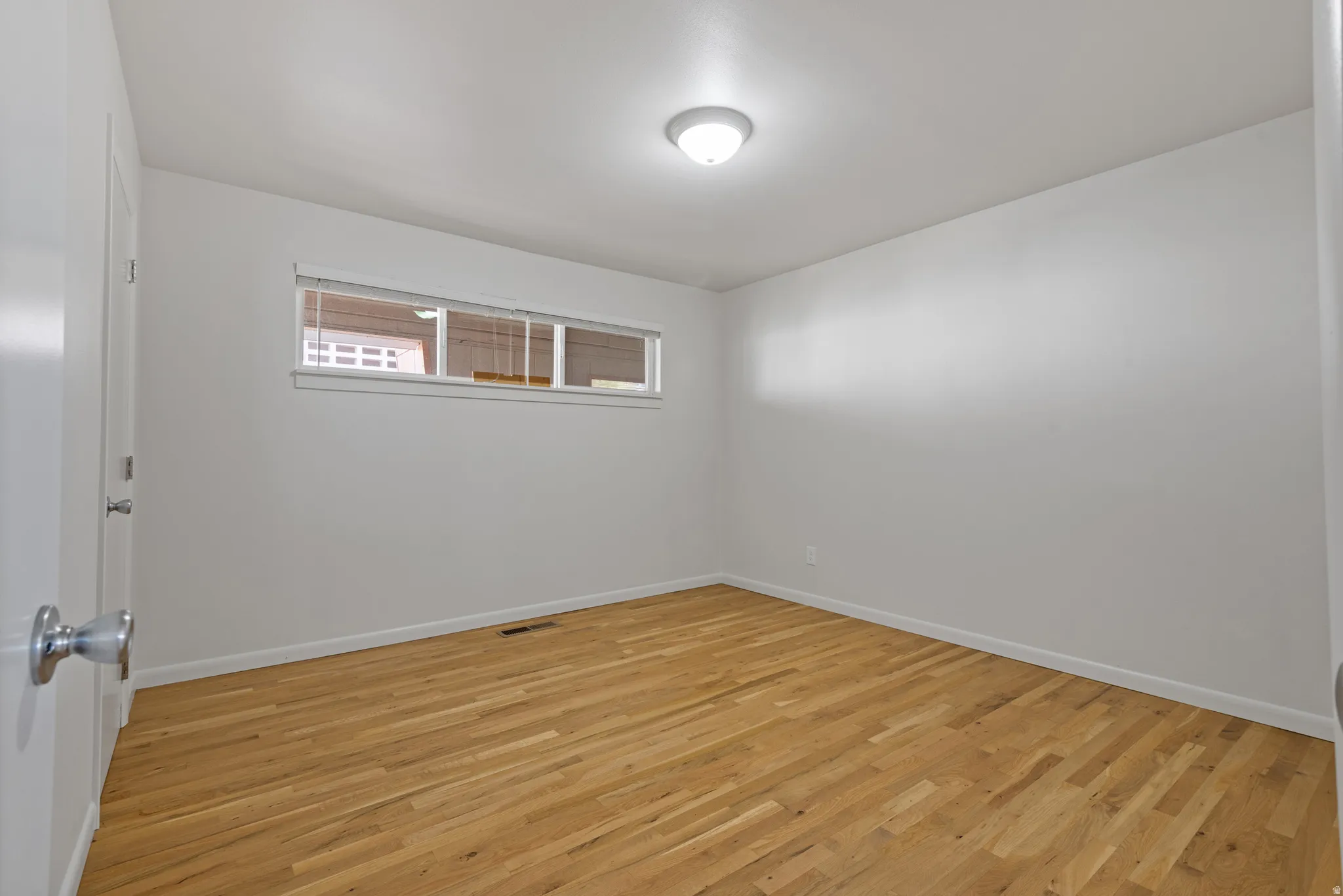 Empty room with light wood-type flooring and baseboards