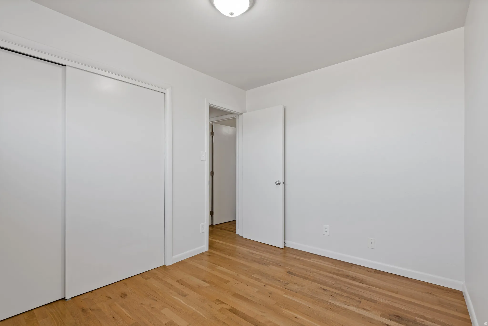 Unfurnished bedroom featuring a closet and light wood-type flooring