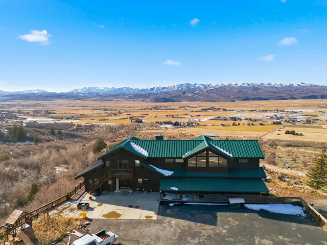 View of front of home featuring a view of countryside, a deck with mountain view, stairs, and a metal roof
