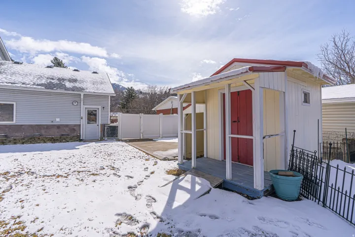 Snow covered structure with a storage shed and a gate