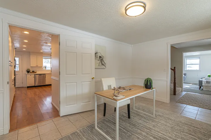 Office area with a textured ceiling, light tile patterned flooring, plenty of natural light, and crown molding