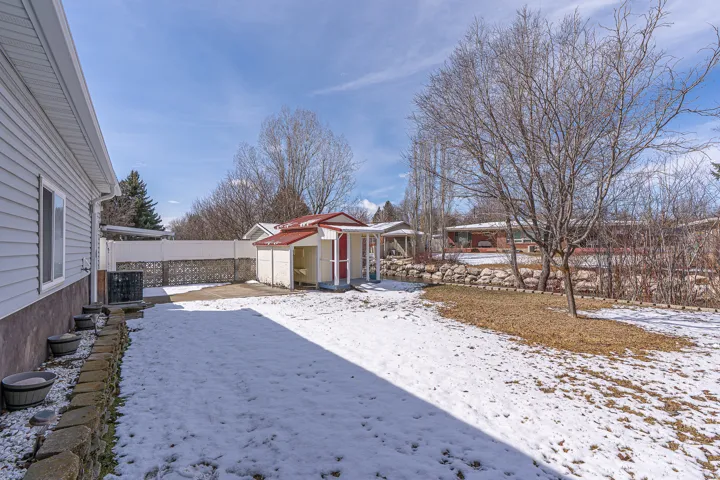 Yard covered in snow with a fenced backyard and a shed