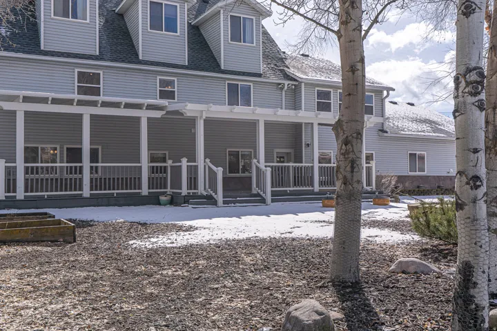 Snow covered property with roof with shingles