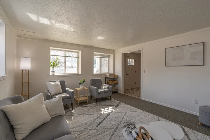 Carpeted living room with a textured ceiling and crown molding