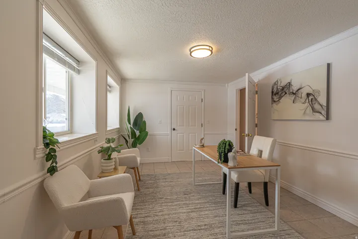 Office space with a textured ceiling, light tile patterned floors, and ornamental molding