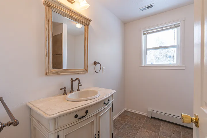Bathroom with baseboard heating and vanity