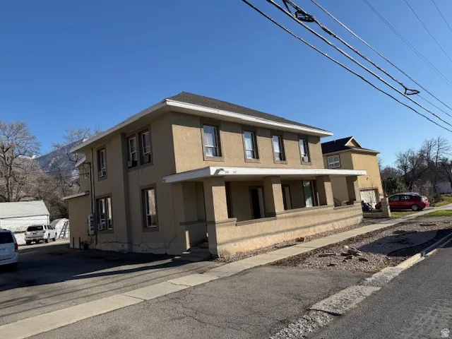 View of front of home with stucco siding and covered porch