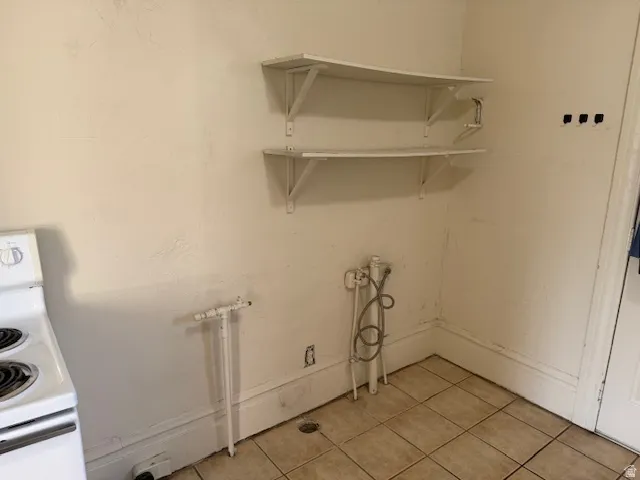 Laundry room with baseboards and light tile patterned floors