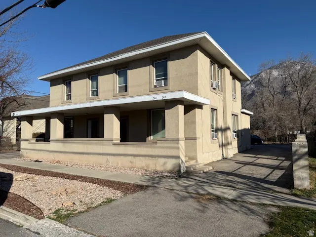 View of home's exterior featuring covered porch, stucco siding, and driveway