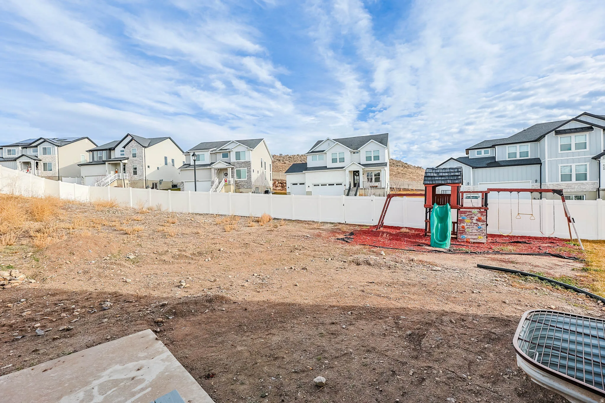 Fenced yard with a residential view and a playground