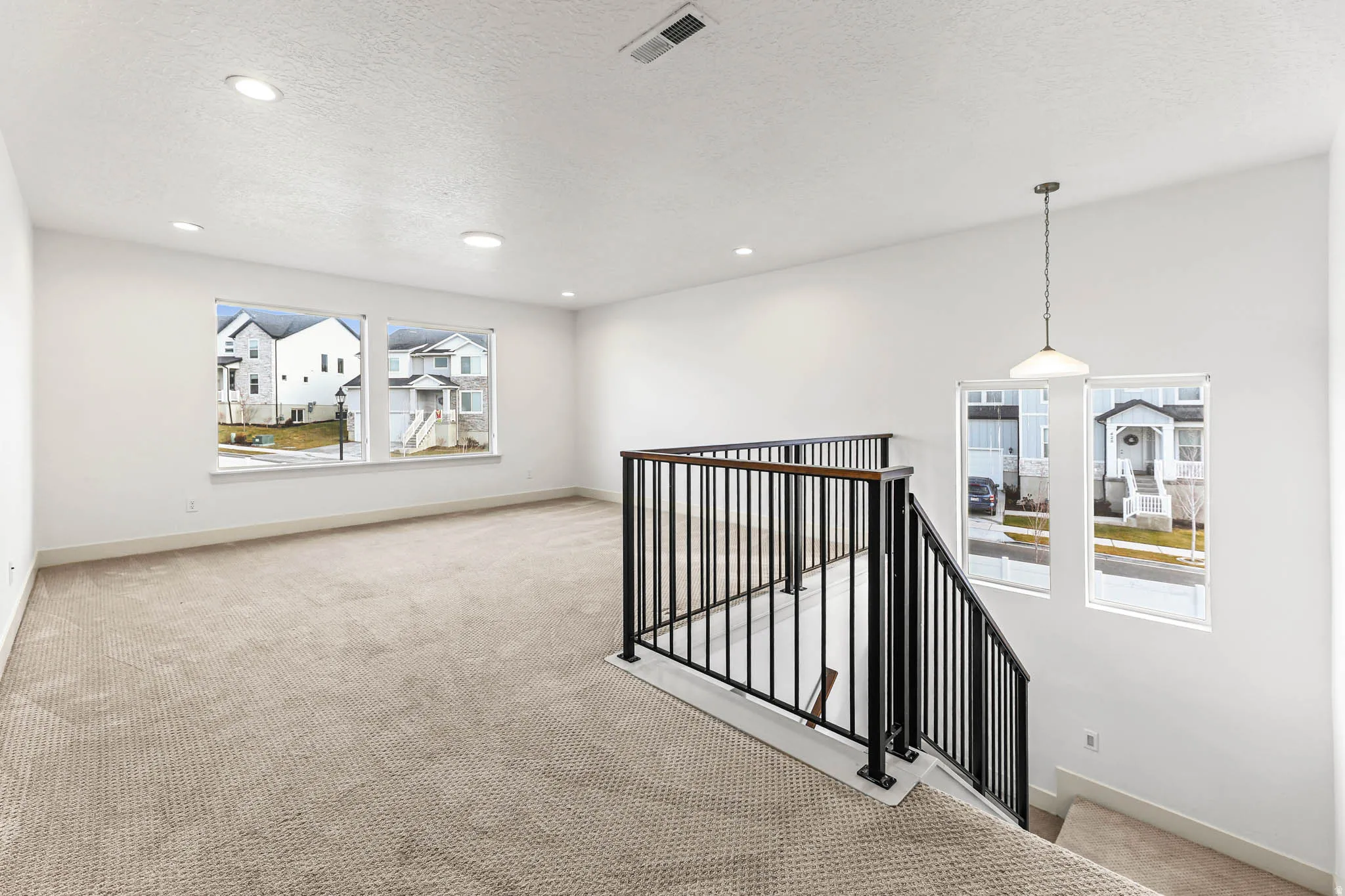 Hall featuring an upstairs landing, carpet floors, a textured ceiling, and recessed lighting