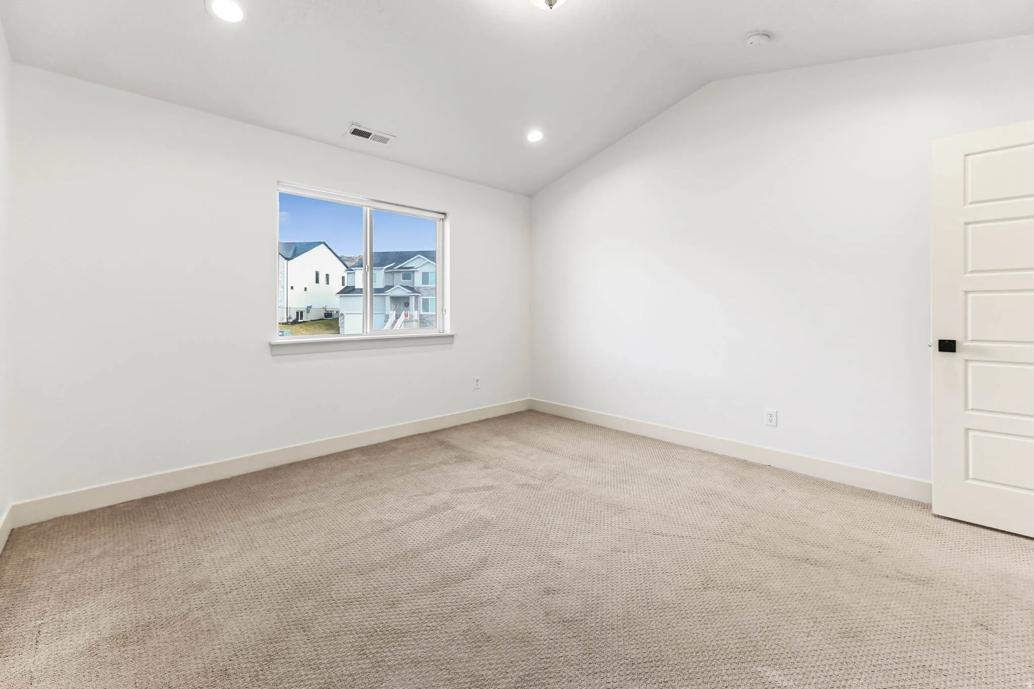 Unfurnished room featuring lofted ceiling, light carpet, and recessed lighting