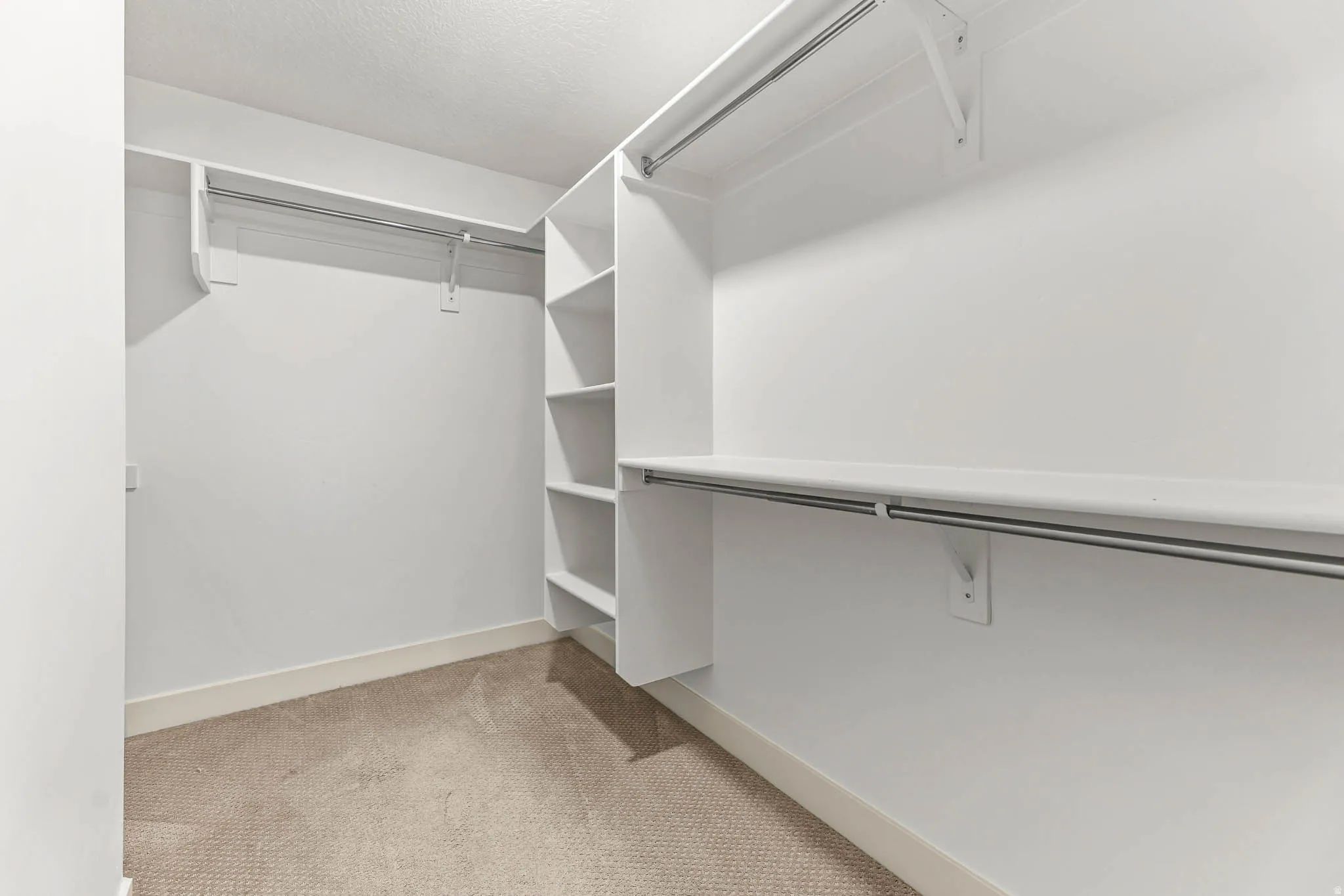 Spacious closet with light colored carpet